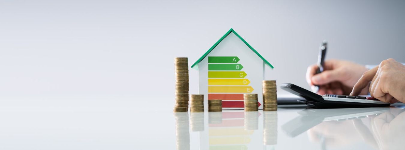 Modellhaus mit Energieausweis, Kleingeld und Taschnrechner