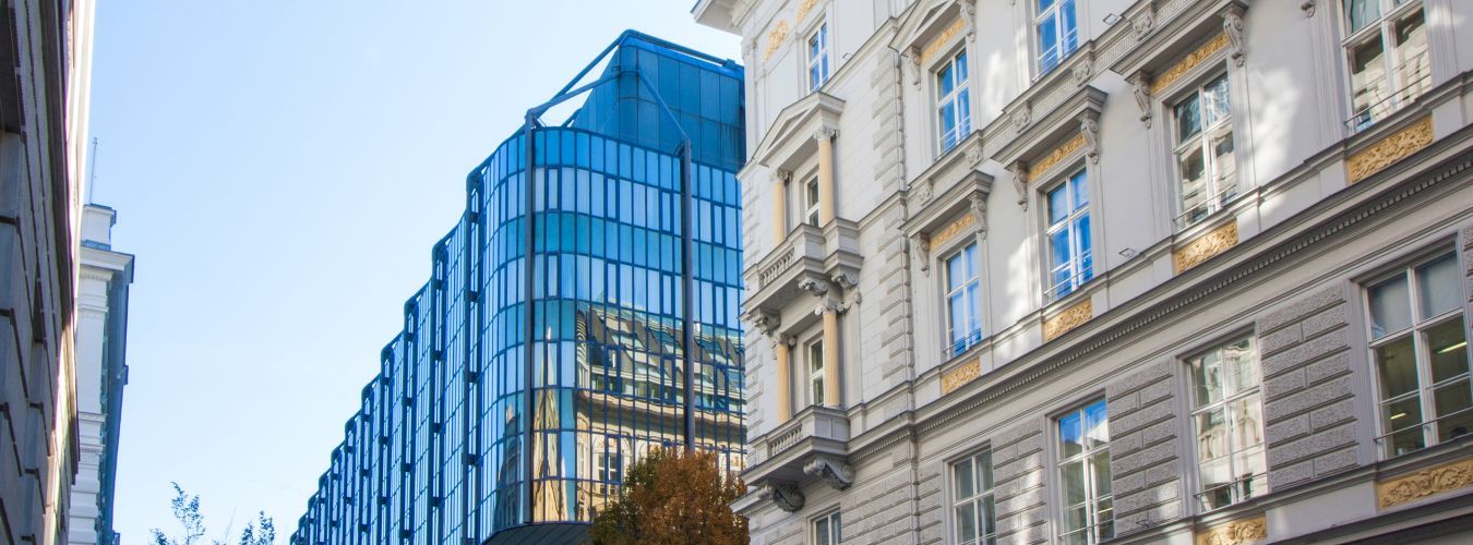 Neubau mit Glasfassade neben klassizistischem Altbau