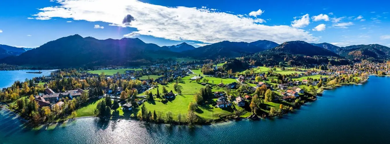 Bebaute Seenlandschaft mit Gebirge im Hintergrund