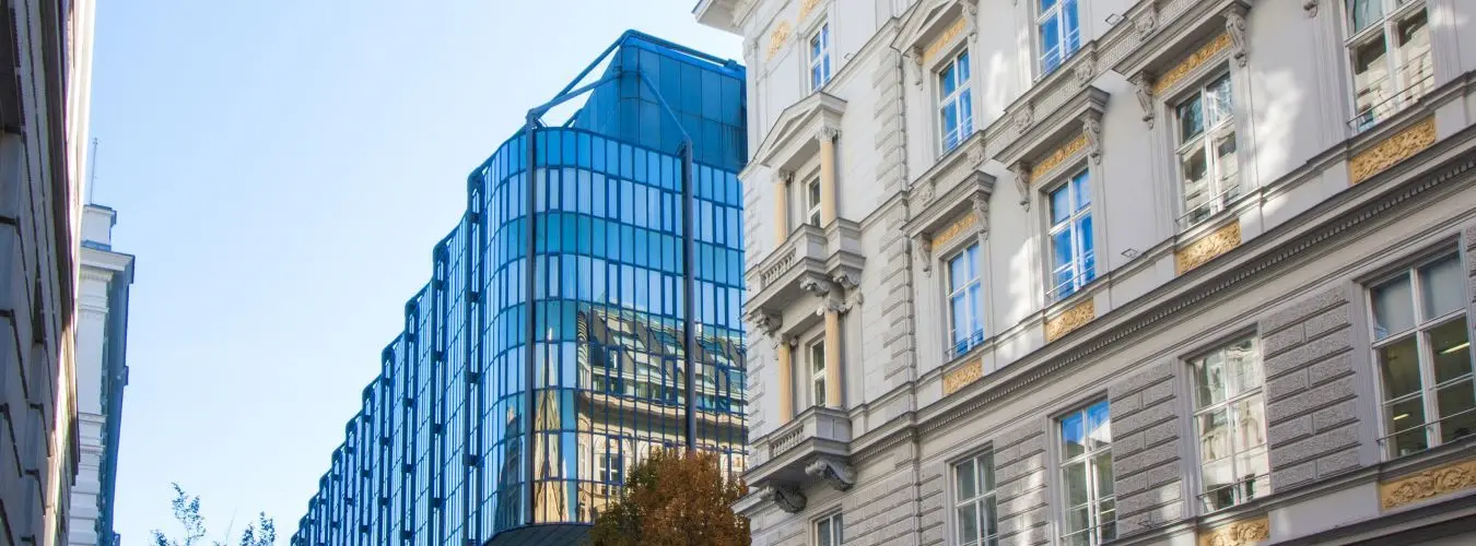 Neubau mit Glasfassade neben klassizistischem Altbau