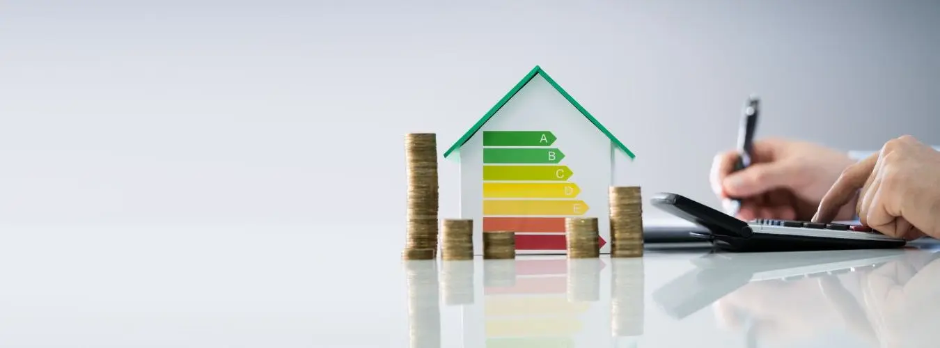 Modellhaus mit Energieausweis, Kleingeld und Taschnrechner