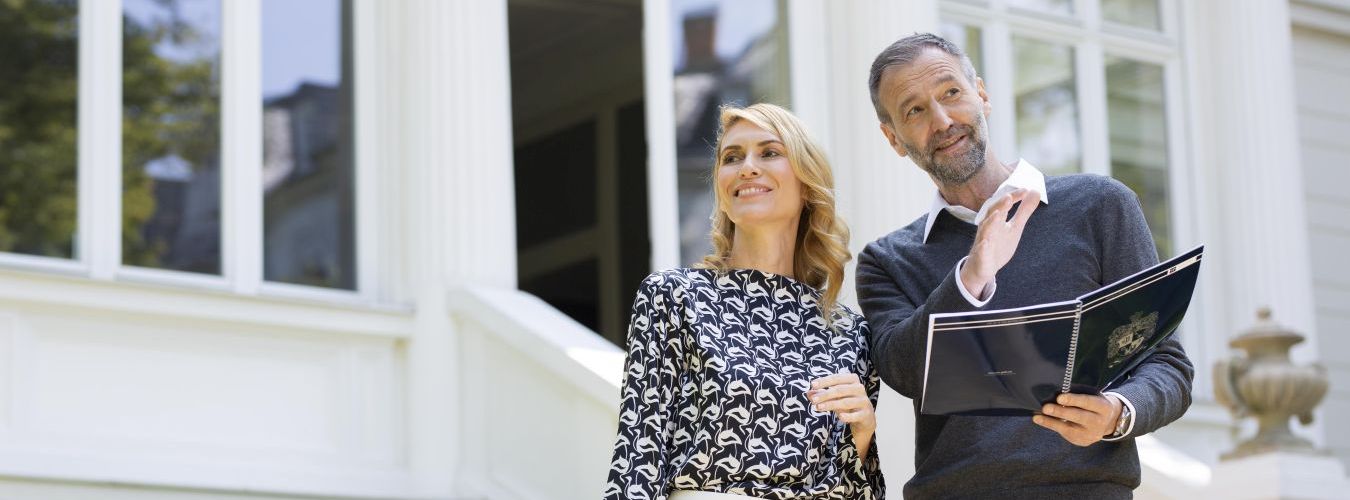 Paar mit Notizblock bei der Besichtigung einer Immobilie