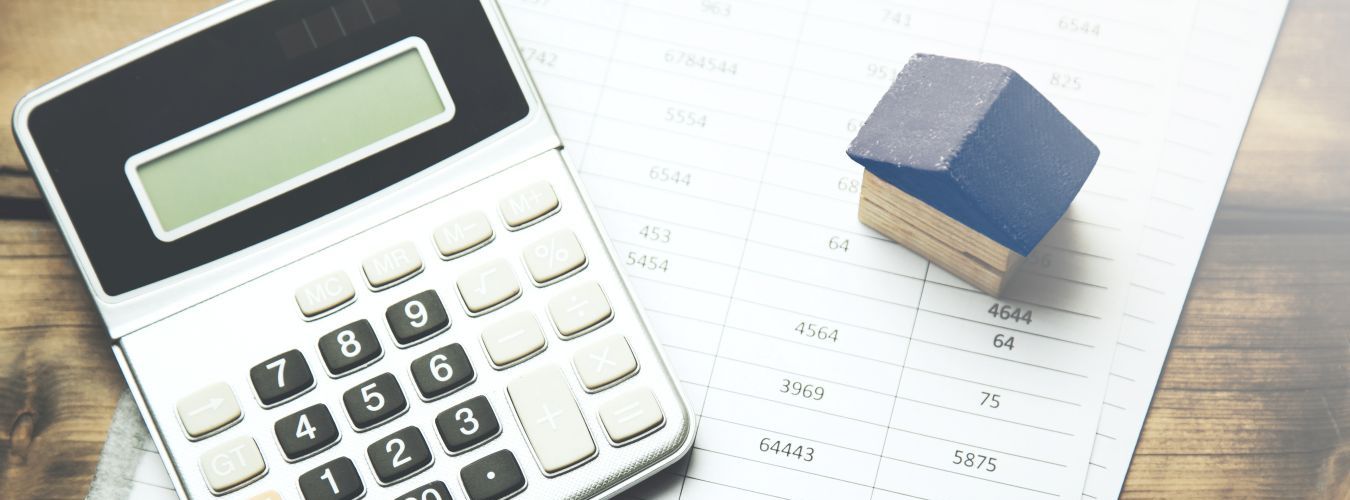 Taschenrechner mit Modellhaus auf Unterlagen