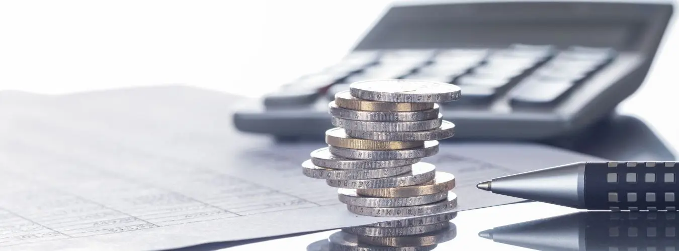 Finanze, euro, mucchi di monete su tavoli con penna e calcolatrice